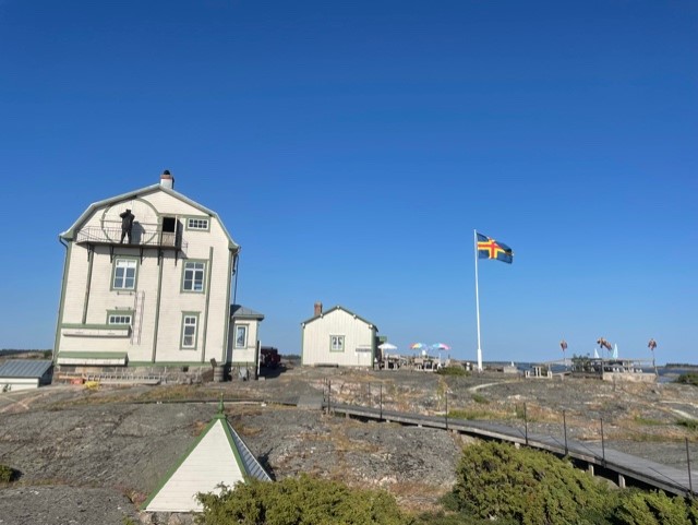 Bild på det gamla fyrvaktarhuset och gubben med kikare.