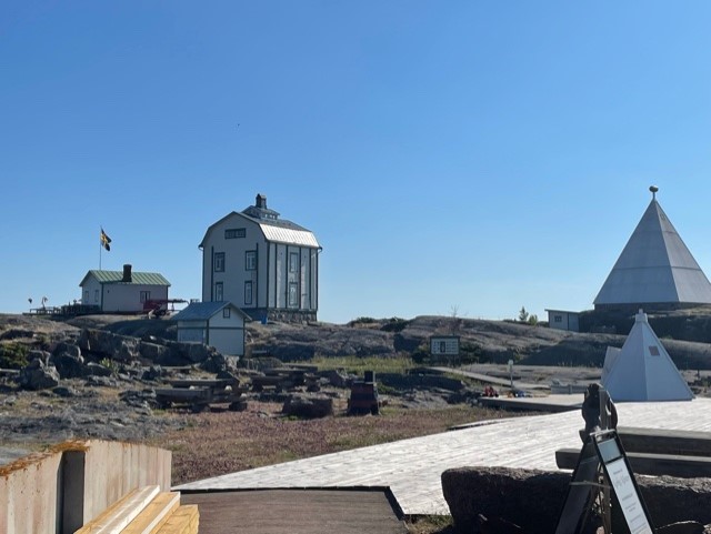 Vy över Kobba klintar. Det gamla fyrvaktarhuset, berget och båken.